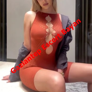 Provocative photo of a woman in an orange cut-out bodysuit seated, with red diagonal text across the image.