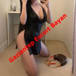 Selfie of a woman kneeling on a carpet in a black outfit, taking a mirror photo with a red escort watermark across the image.