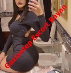 Promotional photo of a woman in a tight black dress taking a mirror selfie in a bathroom; diagonal red text reads 'Gaziantep Escort Bayan'.