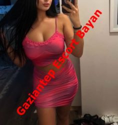 Woman in a pink lace-trim crop top and matching mini skirt takes a mirror selfie in a bathroom; bold red text overlay reads 'Gaziantep Escort Bayan'.