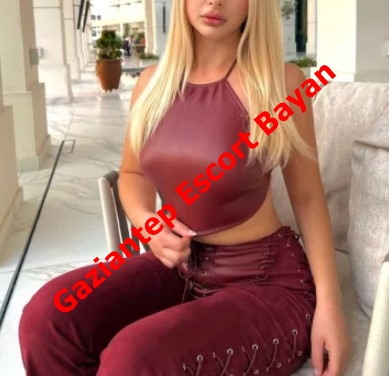 Promotional photo of a blonde woman in a maroon halter top and matching pants seated outdoors, with red text across the image advertising 'Gaziantep Escort Bayan'.
