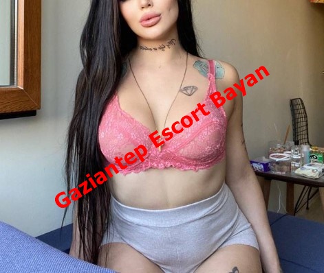 Woman in a pink lace bra and gray shorts sits indoors; bold red text overlay reads 'Gaziantep Escort Bayan' (advertising content).